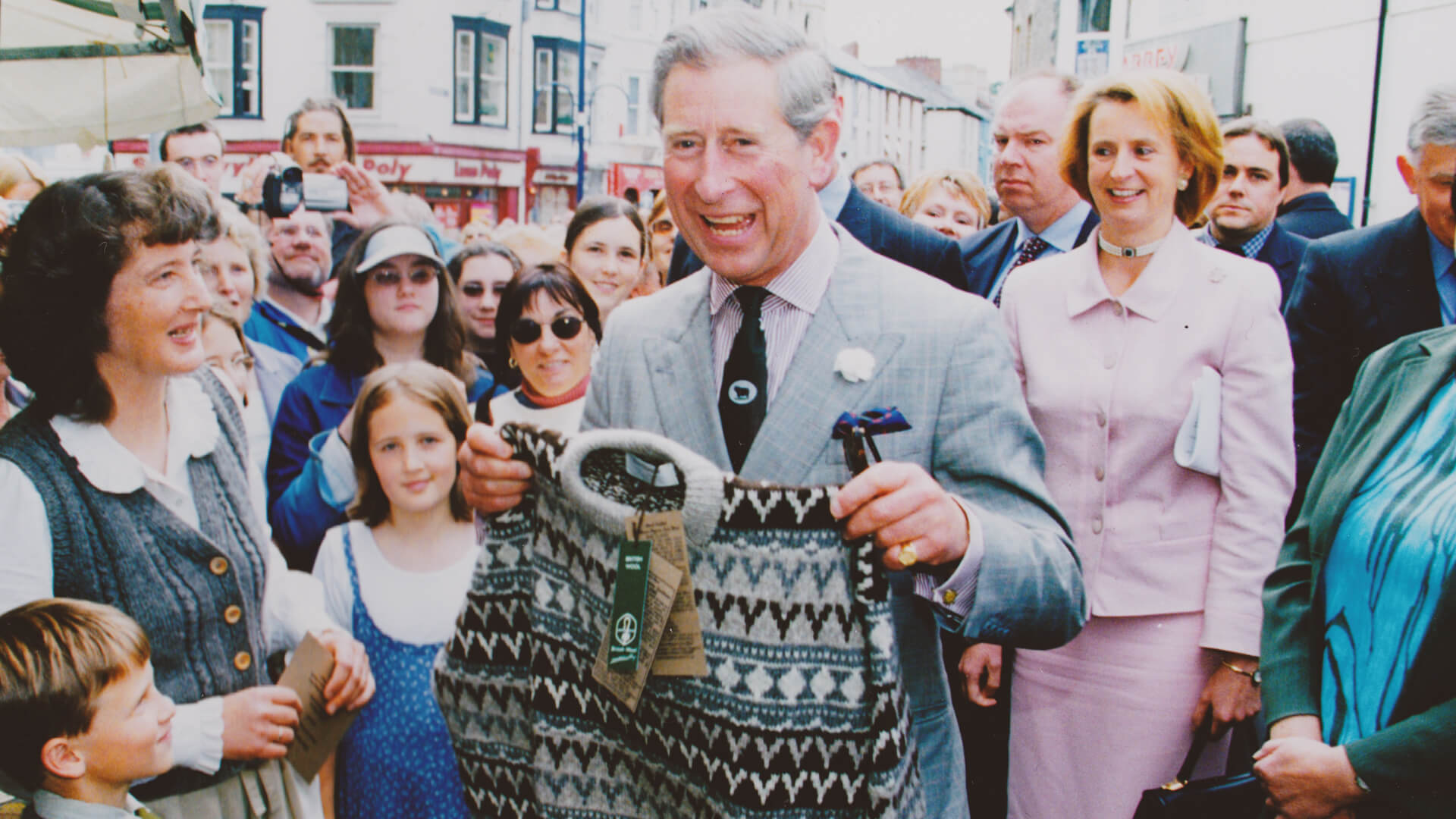 Prince Charles holding a hand-knitted Fair Isle jumper at a Welsh farmers market during his 2001 visit to Garthenor Organic